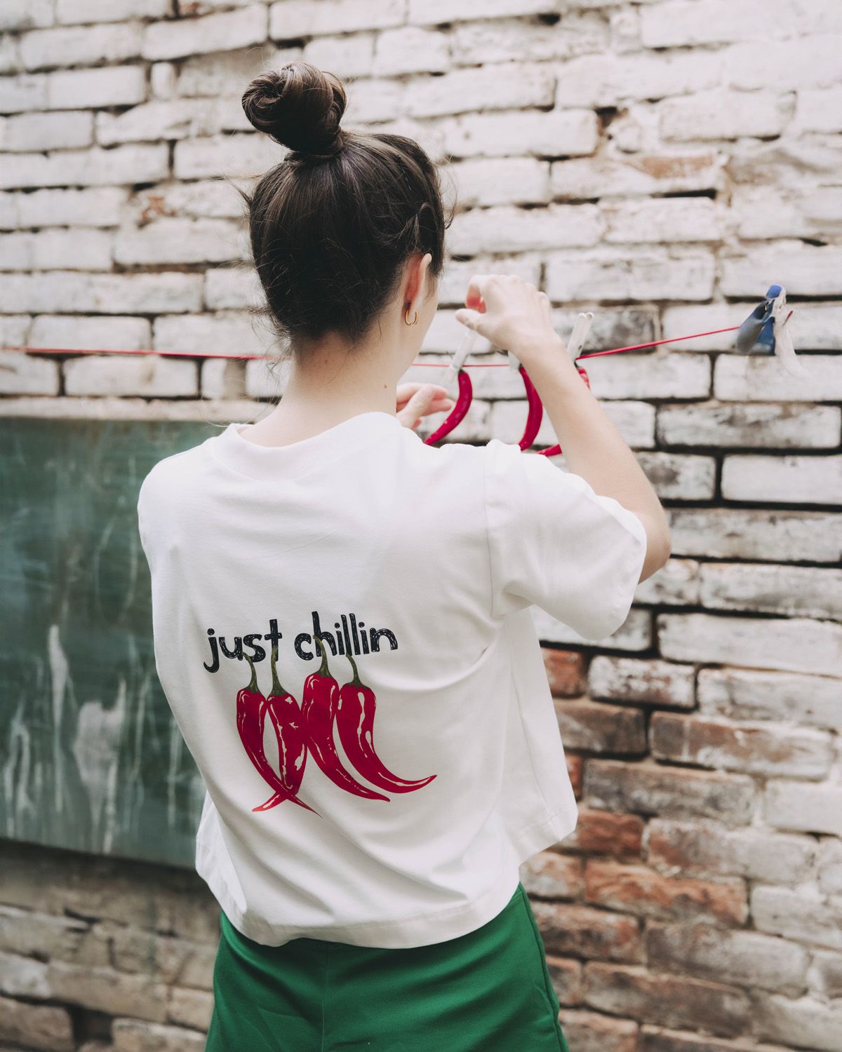 Káťa má na sobě kvalitní bílé tričko crop střihu, které mé na zádech potisk chilli papriček. Pochází z kolekce Mood od značky Buga.