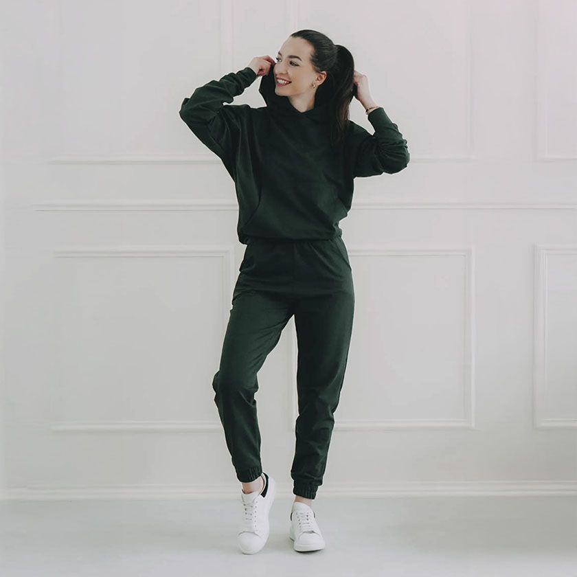 Tmavě zelená mikina s kapucí a tmavě zelené tepláky vytváří skvělý monochromatický outfit. Je to teplákovka z české dílny, která je pohodlná, stylová a trendy. 