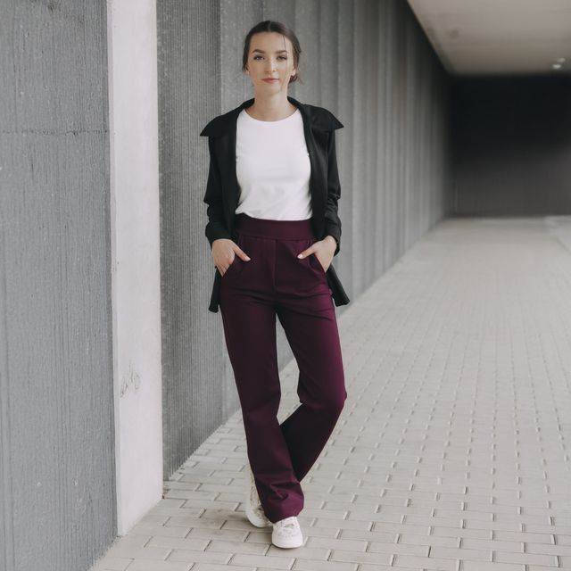 Vínové kalhoty s vysokým pasem a rovným střihem jsou trendy kouskem pro podzim 2025. Spolu s ležérním černým sáčkem a bílým tričkem patří mezi udržitelné kousky, které šijeme s láskou v Česku.