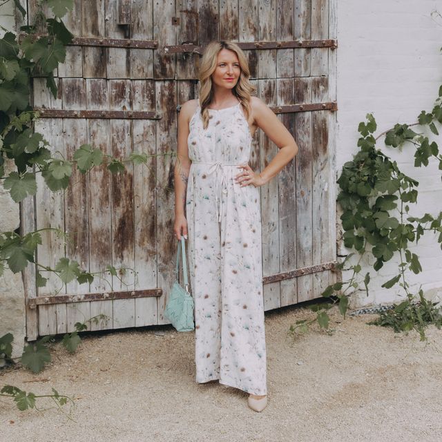 Světlý overal Ishani s jemnými akvarelovými květy má dlouhé široké nohavice, odhalená záda a šňůrku, kterou si upravíte střih přesně tak, jak potřebujete. Ušito v Česku.